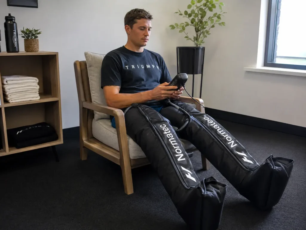Pessoa utilizando a Normatec 3 com as botas pneumáticas durante uma sessão de recovery